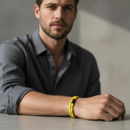 Homem usando pulseira masculina de corda amarela com fecho metálico preto em um visual casual e moderno.