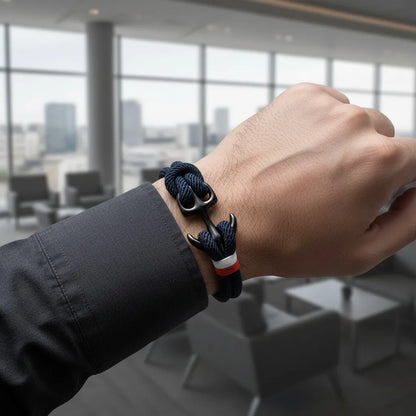 Pulso masculino com pulseira de corda azul-marinho em destaque, em ambiente corporativo com fundo desfocado.
