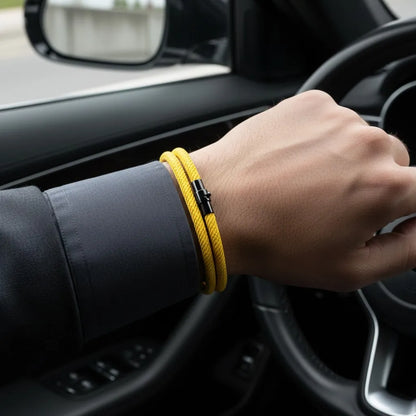 Homem usando pulseira masculina de corda amarela com fecho preto dentro de um carro.