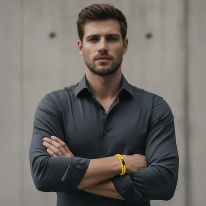 Modelo masculino de braços cruzados usando pulseira de corda amarela com fecho preto.