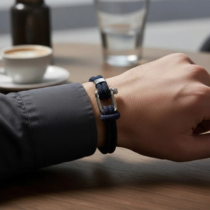 Homem usando pulseira masculina de corda azul-marinho com fecho metálico durante um café.