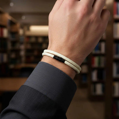 Detalhe de pulseira masculina de corda branca de volta dupla no pulso em uma biblioteca.