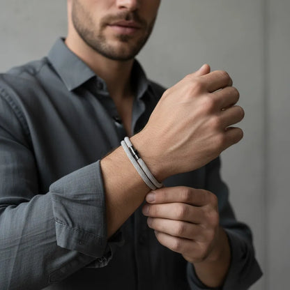 Modelo masculino com camisa social exibindo pulseira de corda cinza de volta dupla.