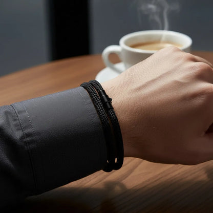 Homem usando pulseira masculina de corda preta durante um café.