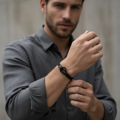 Homem usando pulseira masculina de corda preta com detalhe circular metálico em visual social.