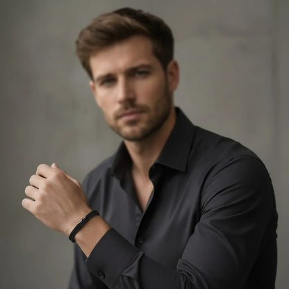 Modelo masculino com camisa preta usando pulseira de corda preta no pulso.