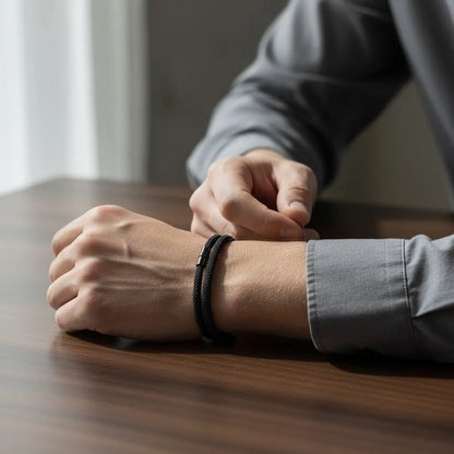 Homem ajustando pulseira masculina de corda preta de volta dupla no pulso.