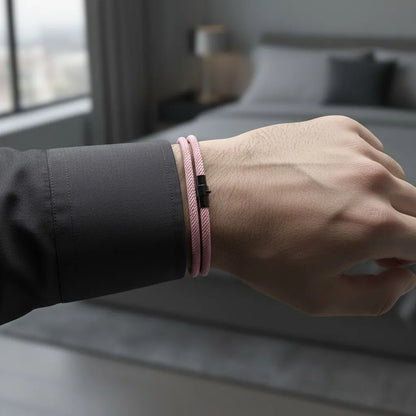 Pulseira masculina de corda rosa de volta dupla com fecho metálico preto no pulso.