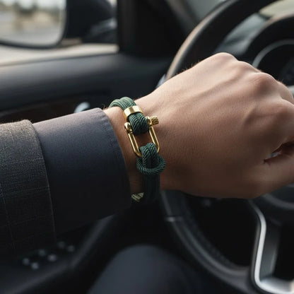 Homem dirigindo um carro enquanto usa pulseira masculina de corda verde com fecho metálico dourado.