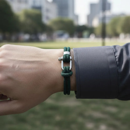 Homem usando pulseira masculina de corda verde com fecho metálico em um parque urbano.