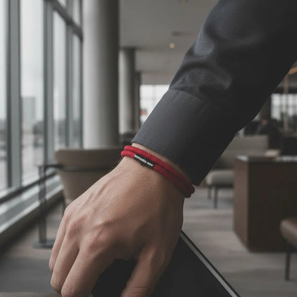 Homem com camisa social usando pulseira masculina de corda vinho em ambiente corporativo.