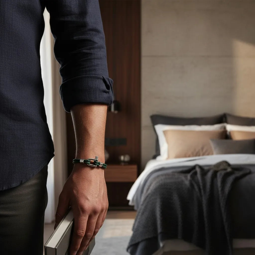 Homem usando pulseira masculina de couro verde trançado com fecho metálico em ambiente elegante.