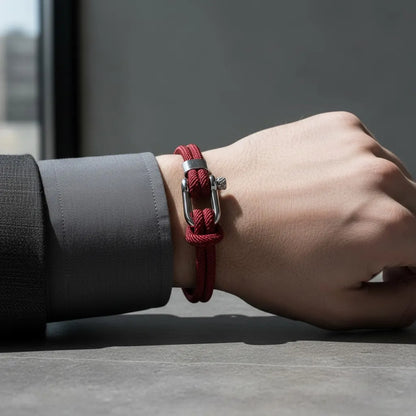Pulseira masculina de corda vermelha de volta dupla com fecho metálico prateado no pulso.